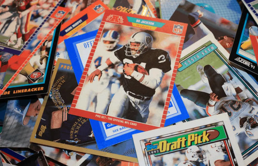 Collection of scattered sports trading cards featuring Football and Baseball players for sports card distribution.