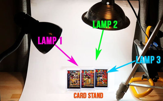 Three trading cards on a stand, illuminated for photographing sports cards.